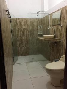 a bathroom with a shower and a toilet and a sink at Hotel San Andres Mompox in Mompos