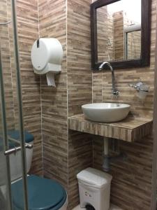 a bathroom with a sink and a toilet and a mirror at Hotel San Andres Mompox in Mompos