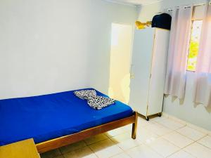 a blue bed in a room with a window at Casa Borboleta na Vila de São Jorge in Alto Paraíso de Goiás +2 photos