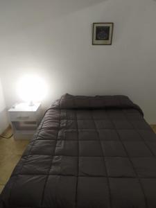 a bed in a room with a nightstand and a bed sidx sidx sidx sidx at Departamentos Anchorena #6 in Ciudad Lujan de Cuyo