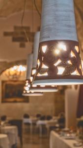 a large light hanging from the ceiling in a restaurant at Kelina Charme Hotel by Cantine Due Palme in Cellino San Marco