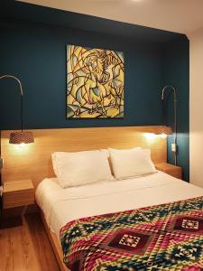 a bedroom with a bed and a painting on the wall at Hotel Casa Merced in Cuenca