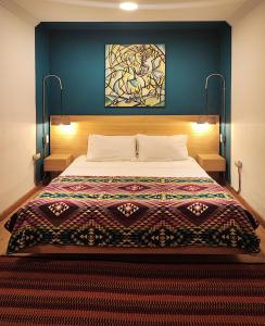 a bedroom with a bed with a quilt on it at Hotel Casa Merced in Cuenca