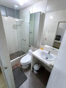 y baño con aseo, lavabo y ducha. en Urban House, en Lima