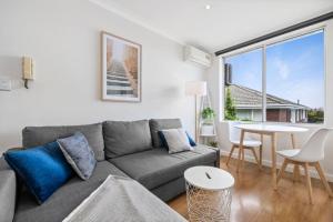 メルボルンにあるTop level one bedroom apartment with MCG viewsのソファとテーブルのあるリビングルーム