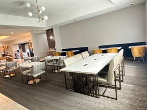 una sala da pranzo con tavoli e sedie bianchi di La Quinta by Wyndham Decatur a Decatur