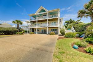 a large white house with palm trees and a driveway at Atlantic Beach Condo - Walk to Beaches! in Atlantic Beach