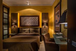 a bedroom with a bed and a desk and a desk at Hotel Capo San Vito by Geocharme in San Vito lo Capo