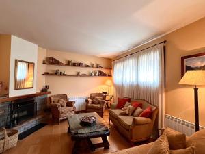 uma sala de estar com um sofá e cadeiras e uma lareira em Apartament de la Vall Ferrera em Areu