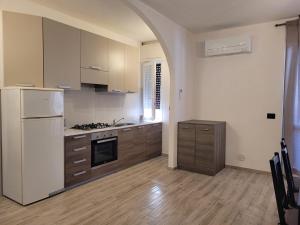 a kitchen with a white refrigerator and a stove at Alberto Quadrilocale a soli 150m dal mare in Marina di Castagneto Carducci