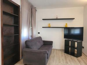 a living room with a couch and a flat screen tv at Alberto Quadrilocale a soli 150m dal mare in Marina di Castagneto Carducci