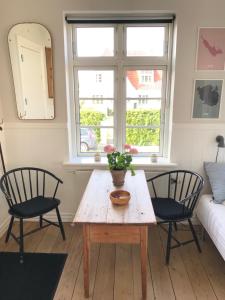 ein Wohnzimmer mit einem Holztisch und zwei Stühlen in der Unterkunft BnB Thuroe in Svendborg