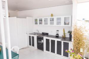 a kitchen with white walls and black appliances at Hostal Casa Dandy in Cartagena de Indias