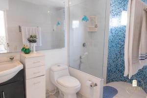 y baño blanco con aseo y ducha. en Hostal Casa Dandy, en Cartagena de Indias