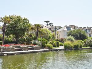 a park with a pond with flowers and houses at Chyvelyn in Perranporth