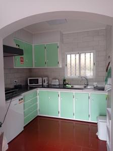 a kitchen with green cabinets and white appliances at Villa Visconde in Nordeste