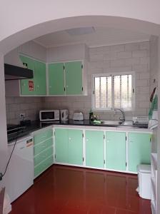 a kitchen with green cabinets and white appliances at Villa Visconde in Nordeste