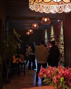 un grupo de personas de pie en una habitación con bar en Hotel Casa Merced, en Cuenca