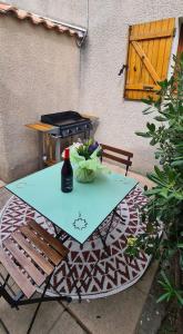 - une table de pique-nique avec une bouteille de vin et un grill dans l'établissement Le Sel du Bonheur, à Gruissan