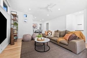a living room with a couch and a table at Beautifully presented home that sleeps ten people in Ocean Grove +4 photos