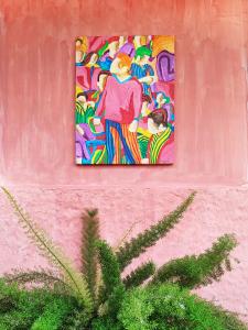 a painting on the side of a pink wall at Hotel Casa Merced in Cuenca