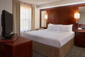 a hotel room with a bed and a flat screen tv at Residence Inn by Marriott Gravenhurst Muskoka Wharf in Gravenhurst