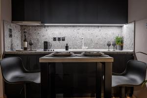 a kitchen with black cabinets and a table with chairs at Eleni Zirganou Studios & Apartments in Milina +46 photos