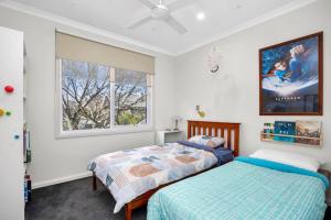 a bedroom with two beds and a window at Explore Frankston South from this lovely home in Frankston