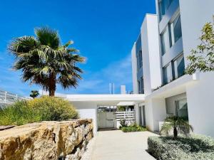 ein weißes Gebäude mit einer Palme davor in der Unterkunft Great 3 bedroom Apt in Marbella-Estepona RDR308 in Estepona