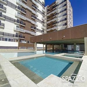 ein Schwimmbad vor einem Gebäude in der Unterkunft Com CAFE SPAZZIO DIROMA e ACESSO ao ACQUA Parque DIROMA TODOS OS DIAS in Caldas Novas