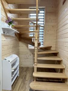 a wooden spiral staircase in a wooden room at Carpathian Dream Apartments in Yaremche