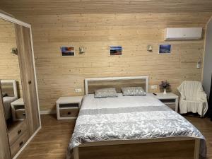 a bedroom with a bed and wooden walls at Carpathian Dream Apartments in Yaremche