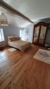 Schlafzimmer mit einem Bett und Holzboden in der Unterkunft Chez Martine in Hanc