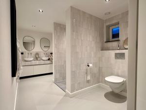 a bathroom with a toilet and two sinks at Stijlvol huisje in de Brabantse natuur! Tuynloodz B in Beers +18 photos