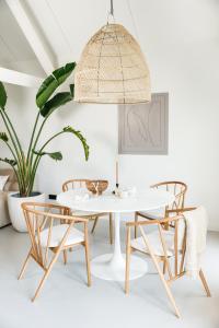 a dining room with a white table and chairs at Stijlvol huisje in de Brabantse natuur! Tuynloodz B in Beers