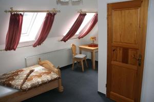 Schlafzimmer mit einem Bett und einem Schreibtisch mit einem Fenster in der Unterkunft Hotel Stadt Pausa in Pausa