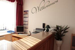 an office with a desk with a computer and a sign on the wall at Hotel Stadt Pausa in Pausa