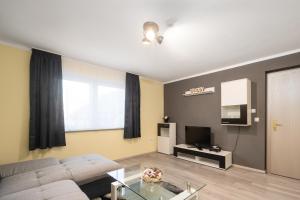 a living room with a couch and a tv at Familienfreundliche 3-Zimmer-Ferienwohnung in Saal an der Donau