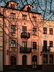 un gran edificio rosa con balcones. en Hoppen House Apartamenty w centrum miasta, en Radom