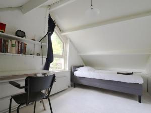 1 dormitorio con cama, escritorio y silla en House in Appelscha on the edge of the forest, en Appelscha