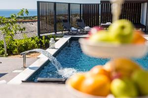 a pool with a water fountain with fruit in the foreground at Villa Luna-Private Heated Pool and sauna in Novalja