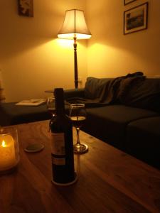 uma garrafa de vinho e um copo sobre uma mesa em Snowberry Cottage em Borve