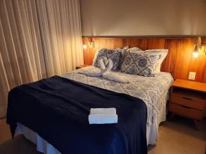 ein Schlafzimmer mit einem Bett mit zwei Handtüchern darauf in der Unterkunft Apartamento Super Charmoso Condomínio OAHU Alto do Imbassaí in Imbassai