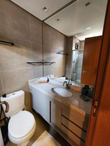 y baño con aseo y lavamanos. en Apartamento Super Charmoso Condomínio OAHU Alto do Imbassaí en Imbassai
