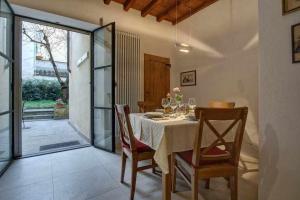 una sala da pranzo con tavolo, sedie e porta in vetro di Il Tulipano Apartment With Patio a Firenze