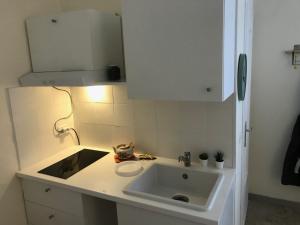 una cucina bianca con lavandino e specchio di Residenza Eli a Piacenza