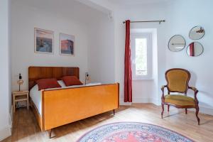 1 dormitorio con 1 cama y 1 silla en Petit Manoir en Ville - Golden Tree - Parking privé en Estrasburgo