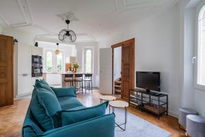 sala de estar con sofá azul y TV en Petit Manoir en Ville - Golden Tree - Parking privé en Estrasburgo