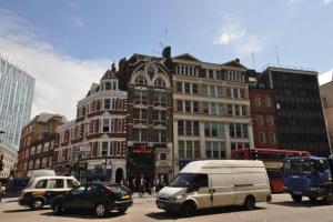 een straat met auto's en een wit busje en gebouwen bij Stylish Central Escape in Londen