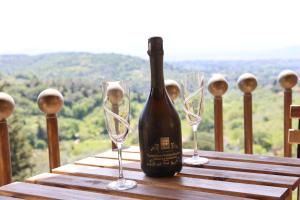 een fles wijn zittend op een tafel met twee wijnglazen bij Bed and Berli in Sesto Fiorentino